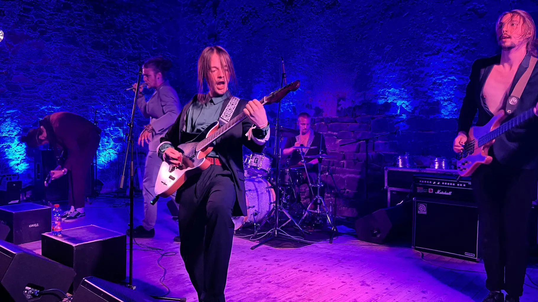 Die Band Grell spielt auf einer in blau violettes Licht beleuchteten Bühne auf Schloss Hundisburg.